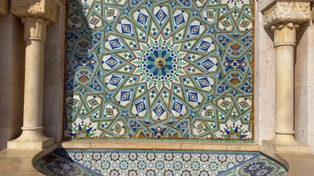 video camera zooms out shot of traditional Zelige mosaic fountain pattern of Morocco, Casablanca mosque Hassan 2