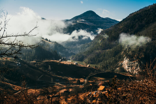 View of the dramatic landscape where the sun kisses the valley floor and clouds dance around the peaks, painting a serene winter scene, Mokra Gora, Zlatibor District, Serbia.
