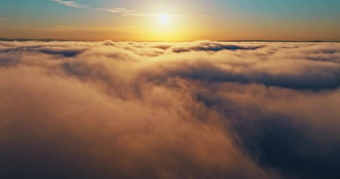 Top down aerial perspective dense clouds summer sunset. Drone shot high above white cloud cover golden hour light. Heavenly nature background majestic atmosphere freedom travel concept scene.