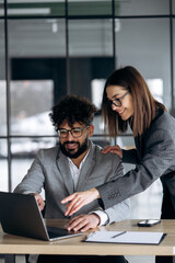 Two business people working at the office and looking into laptop