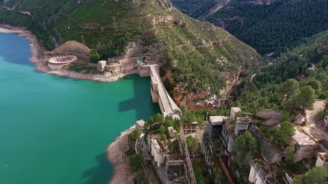 Aerial view of Benageber dam on Turia River, showing concrete gravity structure, spillway intake, reservoir and hydro infrastructure integrated into mountainous terrain