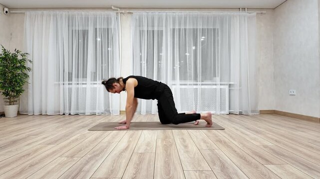 White Man Practicing Cat And Cow Yoga Flow On Mat, Coordinated Inhale And Exhale With Spine Flexion And Extension, Gentle Warmup For Back And Core, Calm Home Atmosphere With Plant.