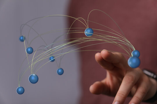 Concept image of a hand interacting with a digital network of spheres, representing communication, technology, and glob