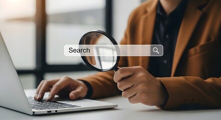 Fototapeta premium A person using a laptop with a magnifying glass to search and find information online with a blurred background