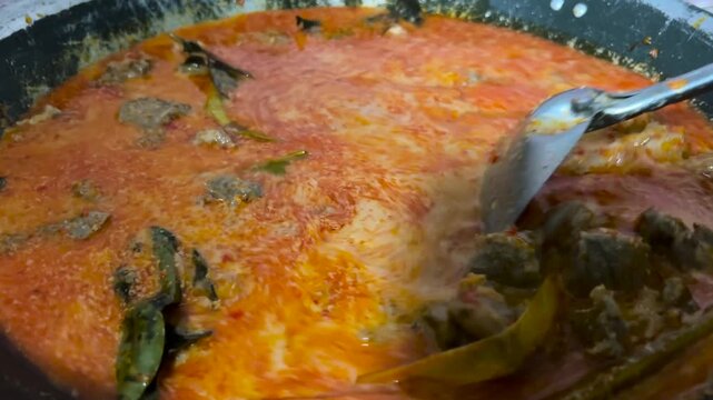 The process of cooking beef rendang with traditional Indonesian spices. A typical Eid al-Fitr menu.