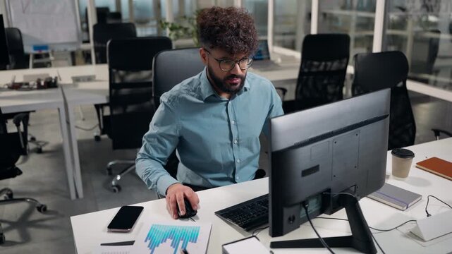 Arabian business man using computer network typing desktop application developing coding programmer ethnic businessman working in office at table male guy specialist marketing manager work online app