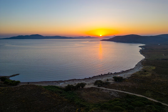 Aerial sunset view over Paralia Skidi beach on Limnos Island, Greece. Golden Mediterranean light reflects across calm sea and quiet shoreline, capturing peaceful natural scenery and evening atmosphere