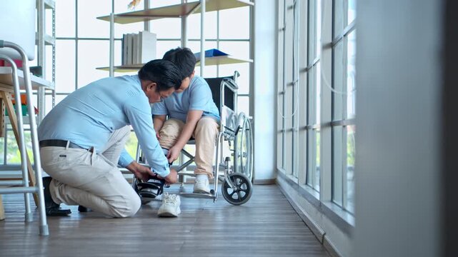 Father adjusting orthopedic ankle brace for young boy in wheelchair, highlighting family support and rehabilitation care