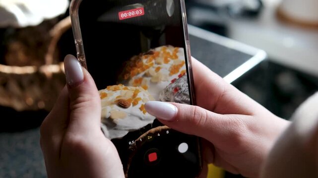 Italian Easter bread colomba pasquale arranged on table as female hands film soft paska and kulich on mobile phone for food blog with festive bakery details