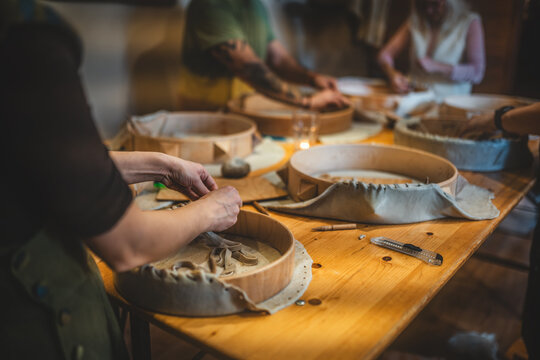 Group of people crafting traditional shamanic frame drums at a creative workshop.