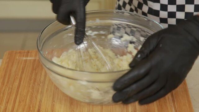 Professional chef mashing baked celery root while making puree