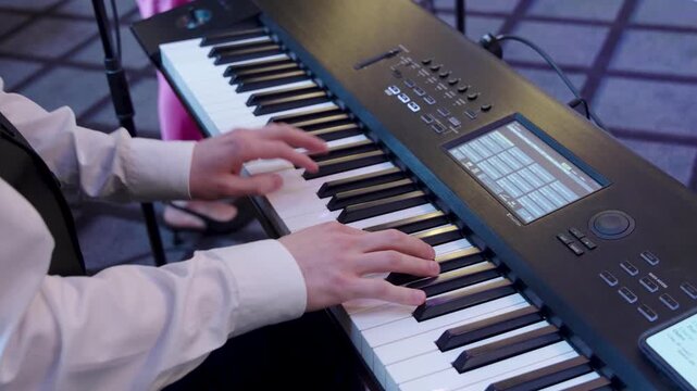 Man playing the piano indoors, expressing creativity and musical performance in a calm setting.