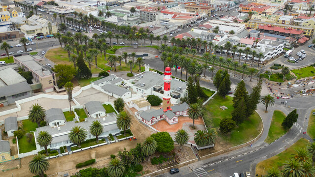 Aerial view of the red and white Swakopmund Lighthouse surrounded by palm trees and colonial architecture in Swakopmund, Erongo Region, Namibia.