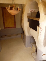 Obraz premium Unique cave dwelling interior with rustic terracotta chandelier and built-in oven