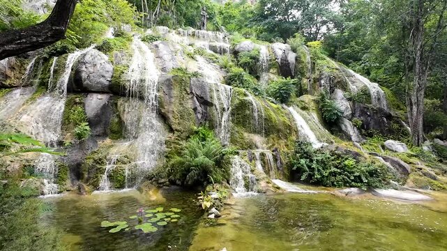 the rock formations and flowing water resemble a natural waterfall, but the area was created within the park to provide a beautiful, refreshing, and relaxing experience for tourists.