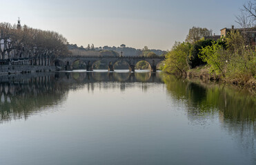 Fototapeta premium Sommieres, France - 03 21 2026: View of a typical stone Roman bridge in South of France
