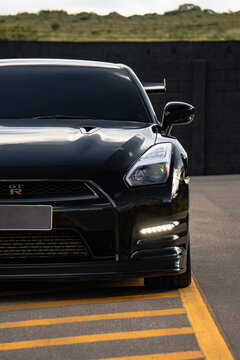 Black Nissan GT-R front half close up, High performance sports car external shot outdoors