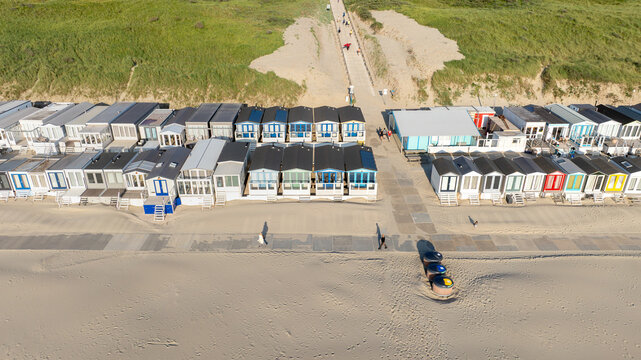 Aerial view of beach houses line the sandy shore, a vibrant contrast against the dunes and sea, Beach Wijk aan Zee, North Holland, Netherlands.