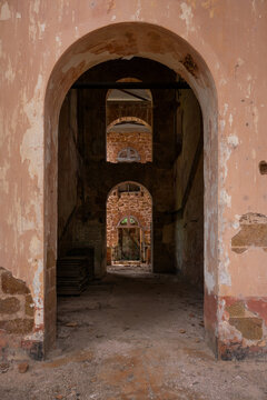View of the interior of ruined stone buildings with multiple arches and crumbling walls in Iles du Salut, Guyana.