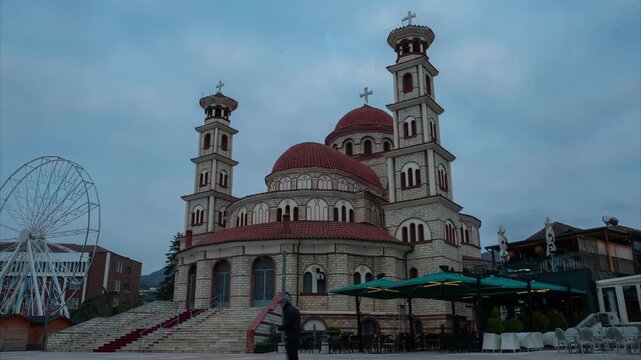 A cinematic evening timelapse of the Resurrection of Christ Cathedral in Kor&ccedil;&euml;, Albania, transitioning from blue hour to night as city lights illuminate the iconic Orthodox architecture.