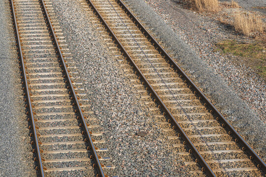 Close up view of parallel railway tracks with gravel ballast texture.