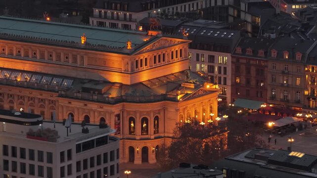 Stunning aerial footage shot with a tripod from a unique place of Alte Oper concert hall in Frankfurt am Main, Germany, glowing warmly against city buildings