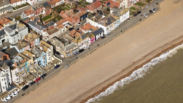 Aerial view of the shoreline where the buildings meet the beach, a symphony of earthy tones offset by colorful facades, Aldeburgh, England, United Kingdom.