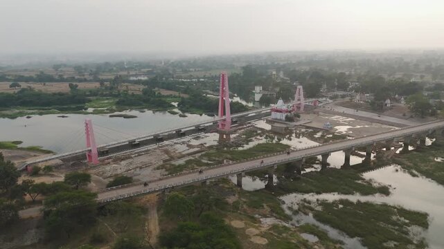 Tola Ghat Patan Shiv Mandir aerial view, Tola Ghat Patan bridge and temple drone shot, Shiv Mandir Tola Ghat Patan riverside aerial, Tola Ghat Patan suspension bridge aerial India stock video.