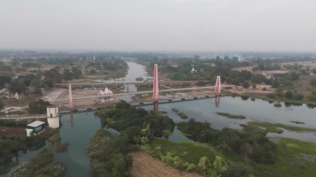 Tola Ghat Patan Shiv Mandir aerial view, Tola Ghat Patan bridge and temple drone shot, Shiv Mandir Tola Ghat Patan riverside aerial, Tola Ghat Patan suspension bridge aerial India stock video.