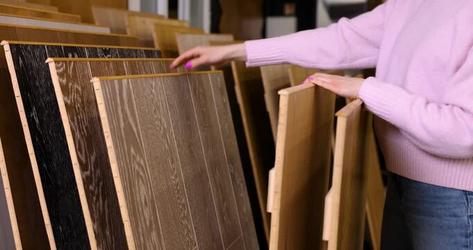 woman at interior design shop choosing flooring materials from samples. house improvement