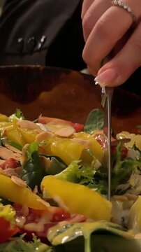 Person enjoying savory lula kebab with crispy french fries and fresh salad, using fork while dining in casual restaurant setting