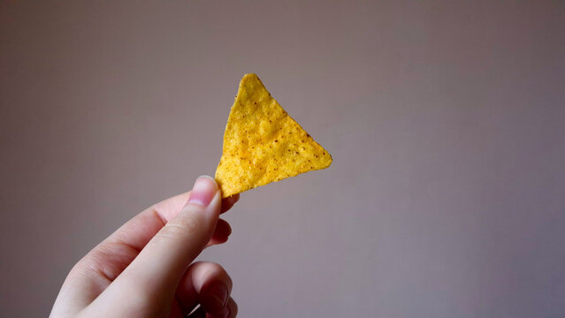 Hand Holding a Single Tortilla Chip, Nachos Mexican Snack Food