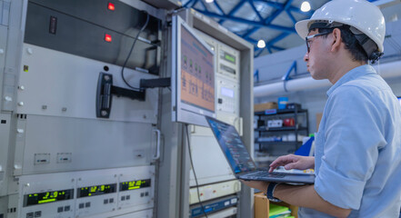 Electrical engineer male checking voltage at the Power Distribution Cabinet in the control room,preventive maintenance Yearly,inspecting power system and control panel in industrial factory © reewungjunerr