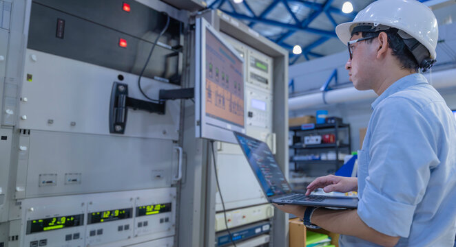 Electrical engineer male checking voltage at the Power Distribution Cabinet in the control room,preventive maintenance Yearly,inspecting power system and control panel in industrial factory