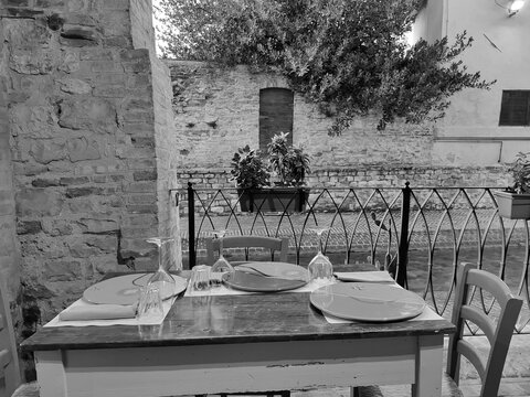 Foligno, Umbria, Italy - September 26, 2025, perspective view of a table set in a restaurant within the complex of Foligno's charming historic canal, the Canale dei Molini.