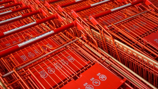 Row of bright red metal shopping carts in close-up