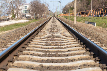 Fototapeta premium A distant railway track between a lake and a forest in spring