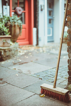 Close-up of A wooden broom leaning against a brick wall in a city street in autumn, Luxembourg