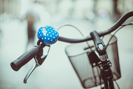 Close-up of a blue bicycle bell with polka dots in a city street