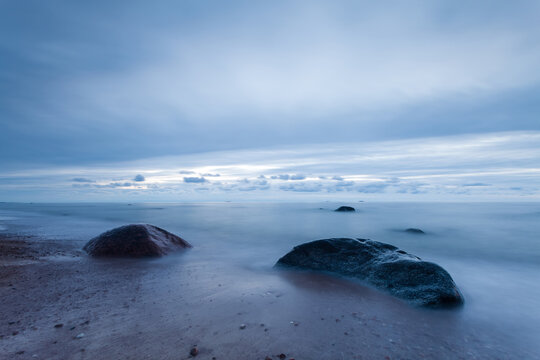Rocks on a sandy beach by the Baltic Sea at dusk, Lithuania