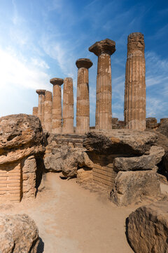 View of the ancient Doric columns of the Temple of Heracles at the Valley of the Temples under a blue sky in Agrigento, Sicily, Italy.