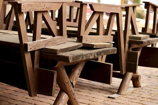 Close-up of Upside down wooden chairs on wooden tables on an outdoor terrace