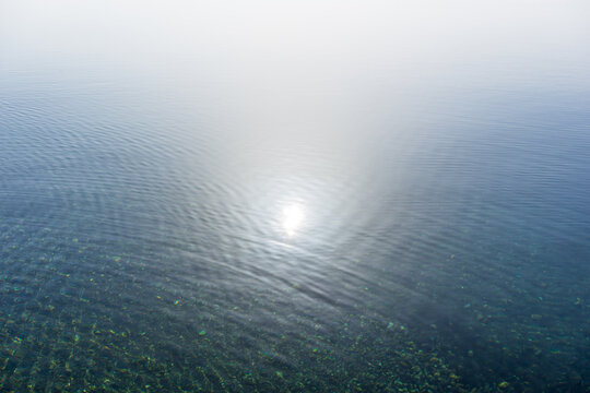 Die Sonne spiegelt sich auf einer ruhigen Wasseroberfl&auml;che