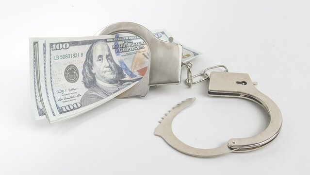 Shiny handcuffs with hundred-dollar bills