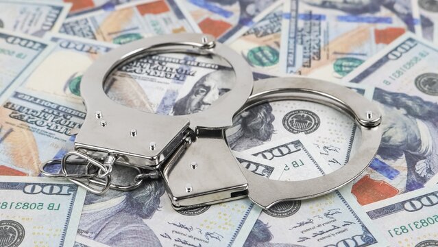 Shiny handcuffs with hundred-dollar bills