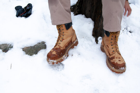 Botas  mojadas sobre la nieve rocas