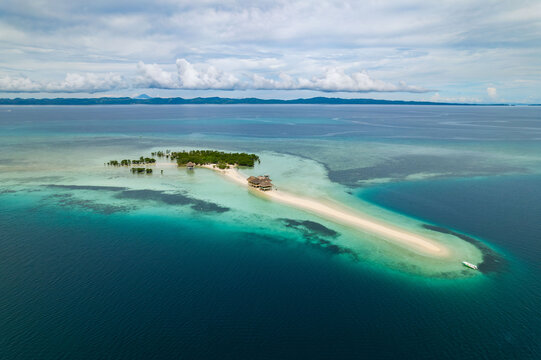 Aerial view of the sandbar stretching out into the ocean, contrasting vividly against the deep blue waters, Mobo, Bicol, Philippines.
