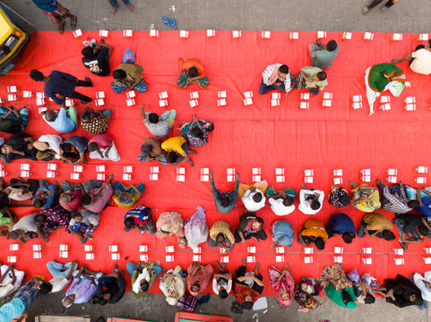 Dhaka, Bangladesh - 17 March 2026: Aerial view of a vibrant red canvas dotted with people and white objects, creating a striking pattern from above.