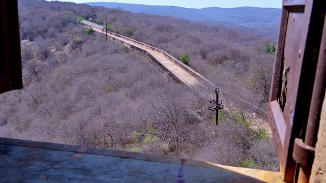 Daytime video view from Jaigarh Fort Jaipur showing hill road and forest area of Aravalli range, with long fort wall pathway and dry jungle landscape visible in the background Rajasthan.