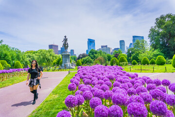 Fototapeta premium Woman strolls through vibrant purple flowerbeds